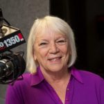 portrait of Pat Kerrigan at her radio station with microphone