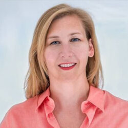 Wendy Nystrom, a woman with blonde hair wearing a coral button-up shirt, smiles at the camera against a light background.