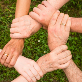 several hands connected in a circle of mutual support