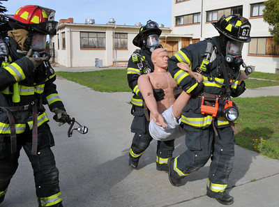 Group of firefighters carrying practice dummy