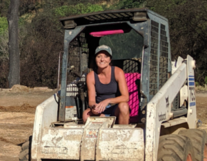 woman smiling seated on a construction earth mover machine