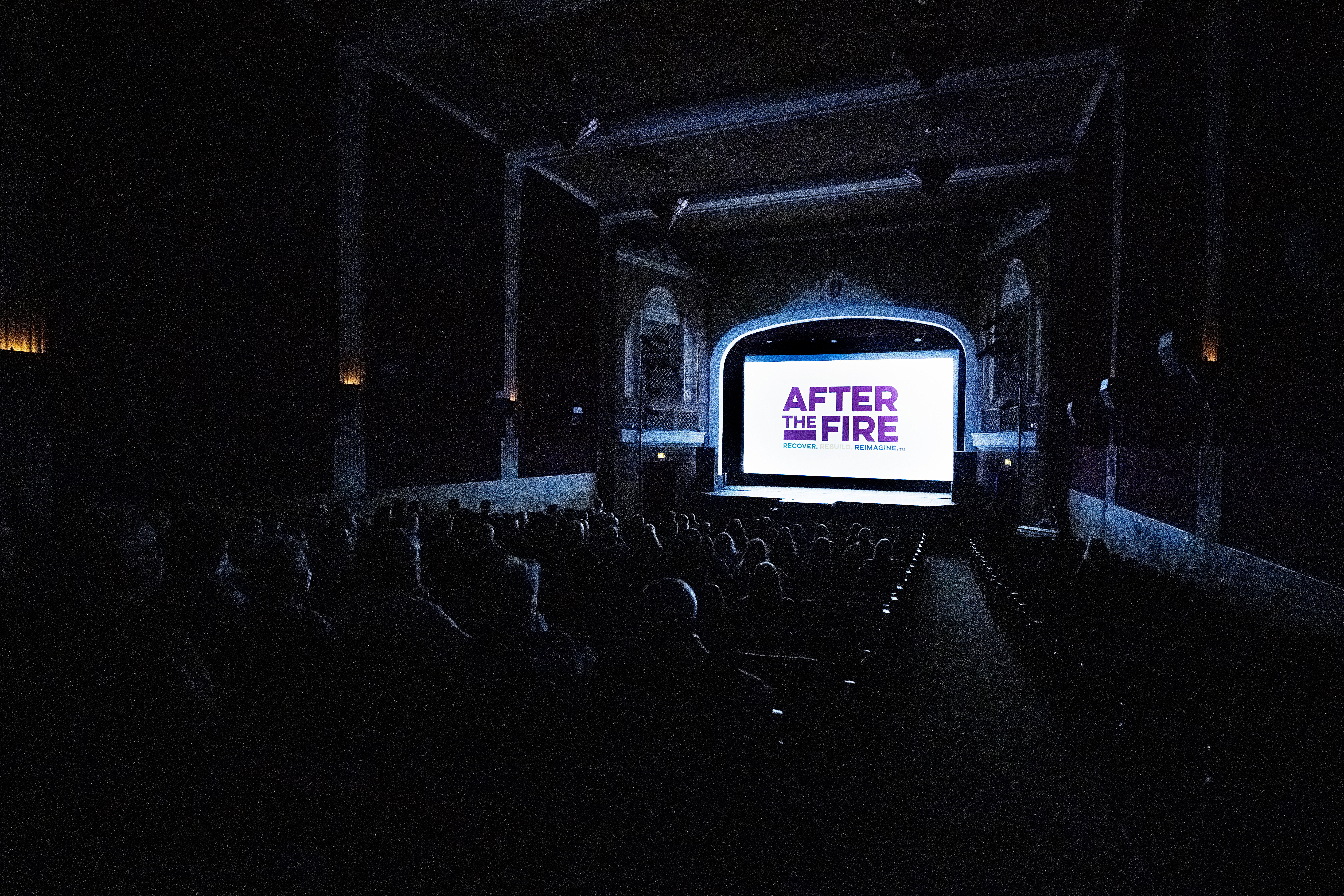 inside the dark movie theater with After the Fire Logo on the screen