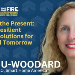 Smiling woman with curly blonde hair stands beside text about climate-resilient housing at the Wildfire Leadership Summit.