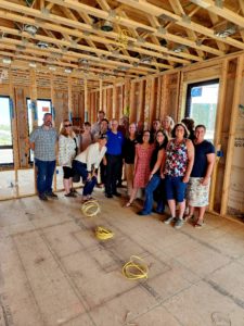 A group of people posing for a photo inside of a house being built