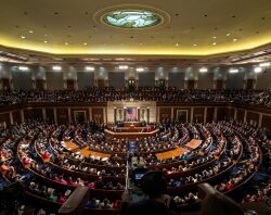 A large crowd sits in the U.S. House chamber during a formal government assembly or address.