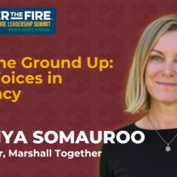 Tawnya Somauroo smiles in front of a banner for the 2025 Wildfire Leadership Summit event.