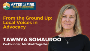 Tawnya Somauroo smiles in front of a banner for the 2025 Wildfire Leadership Summit event.