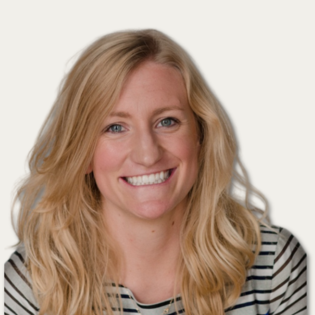 Smiling woman with long blonde hair wearing a striped shirt, against a plain light background.