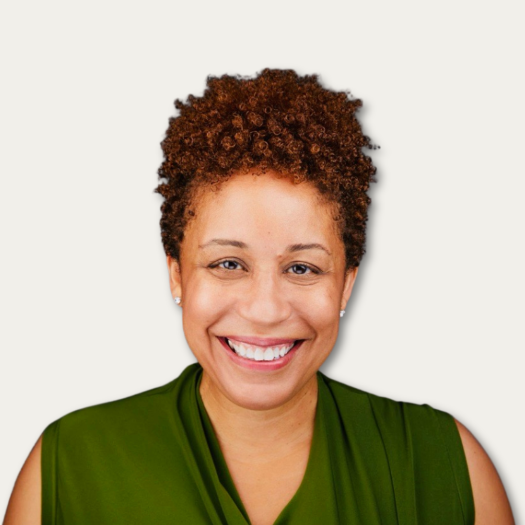 Smiling woman with short curly hair, wearing a sleeveless green top, on a plain light background.