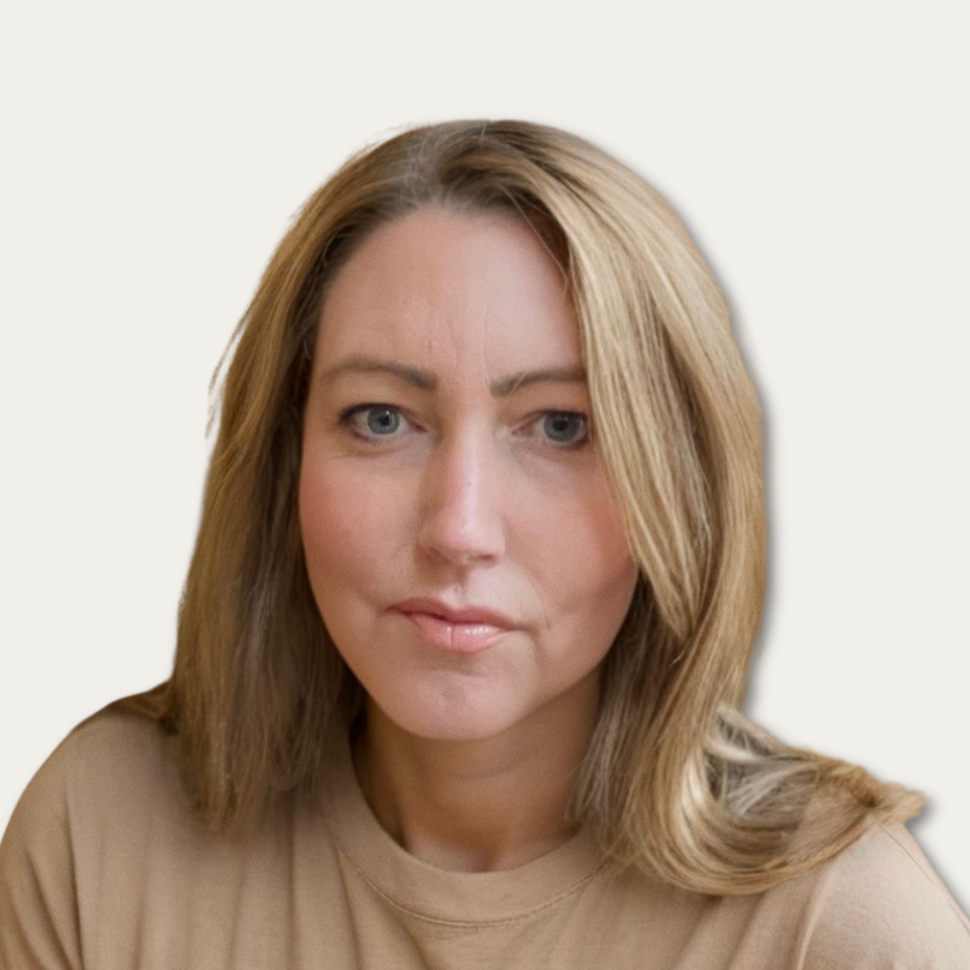 Woman with straight, shoulder-length blonde hair, wearing a beige top, facing the camera with a neutral expression.