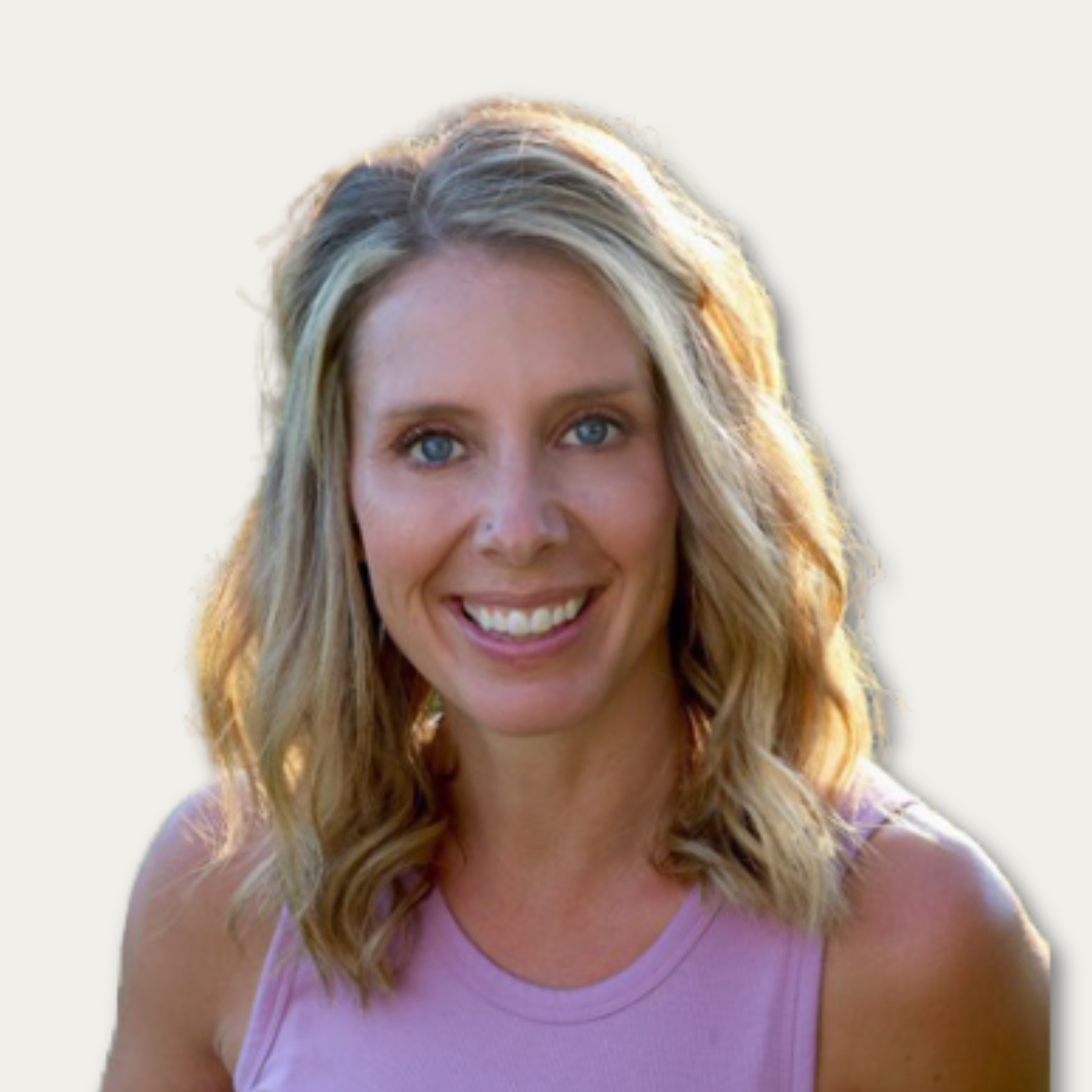 Smiling woman with wavy blonde hair wearing a sleeveless pink top, facing the camera against a light background.