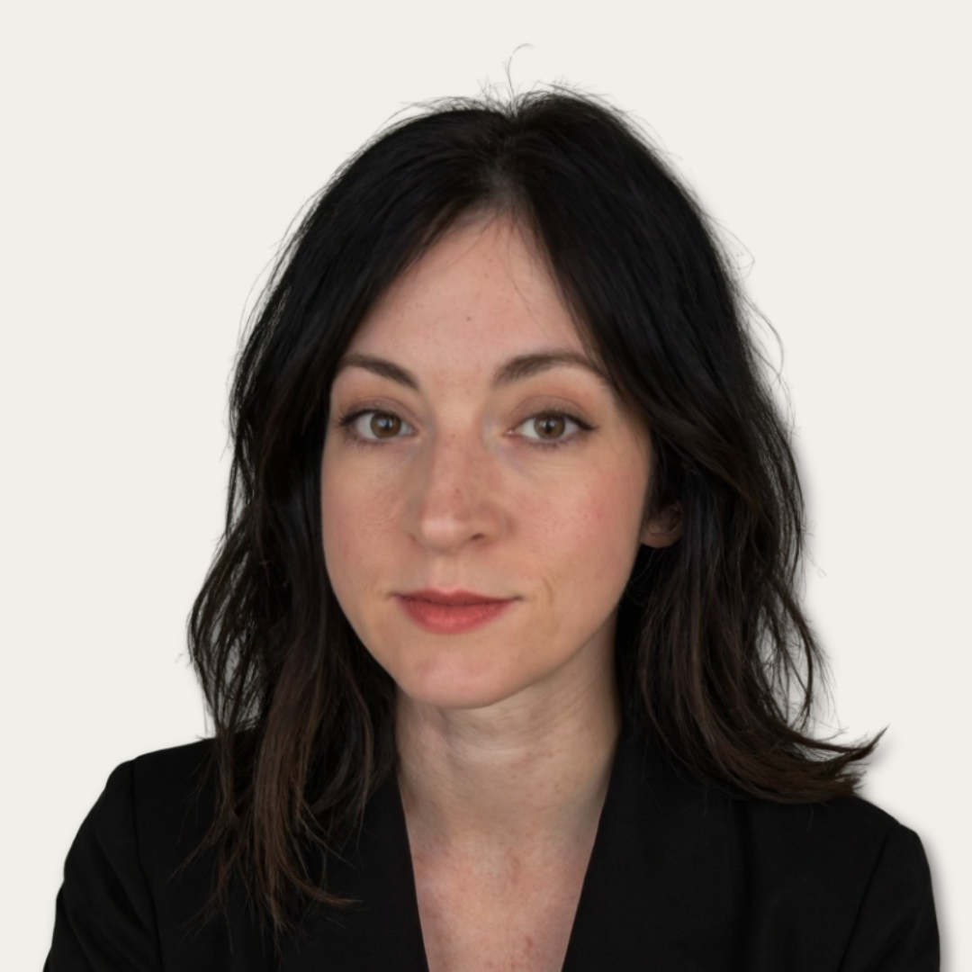 Woman with shoulder-length dark hair, wearing a black blazer, looking at the camera with a neutral expression.