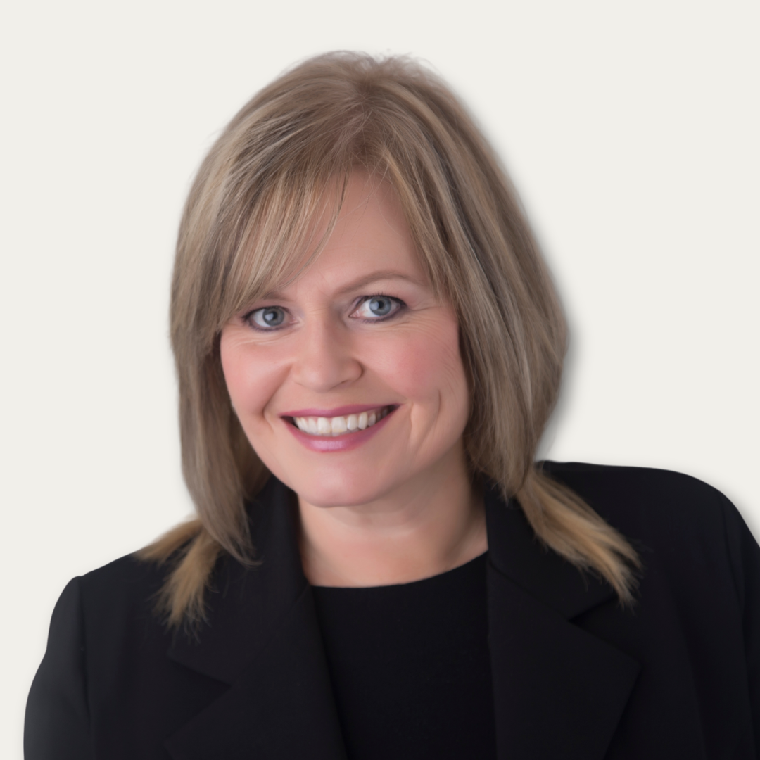 Smiling woman with blonde hair in a black blazer against a plain white background.
