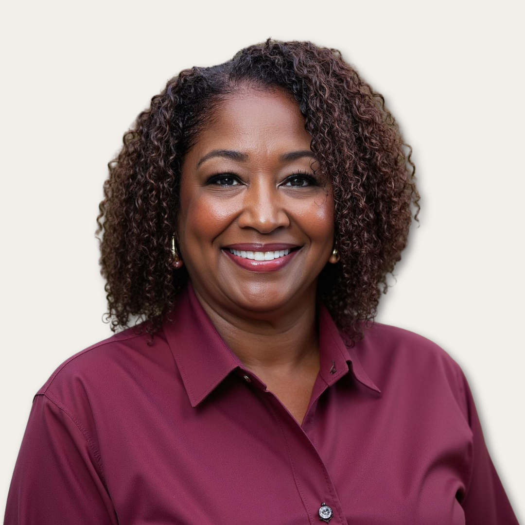 Smiling woman with curly hair wearing a maroon shirt, photographed against a plain light background.