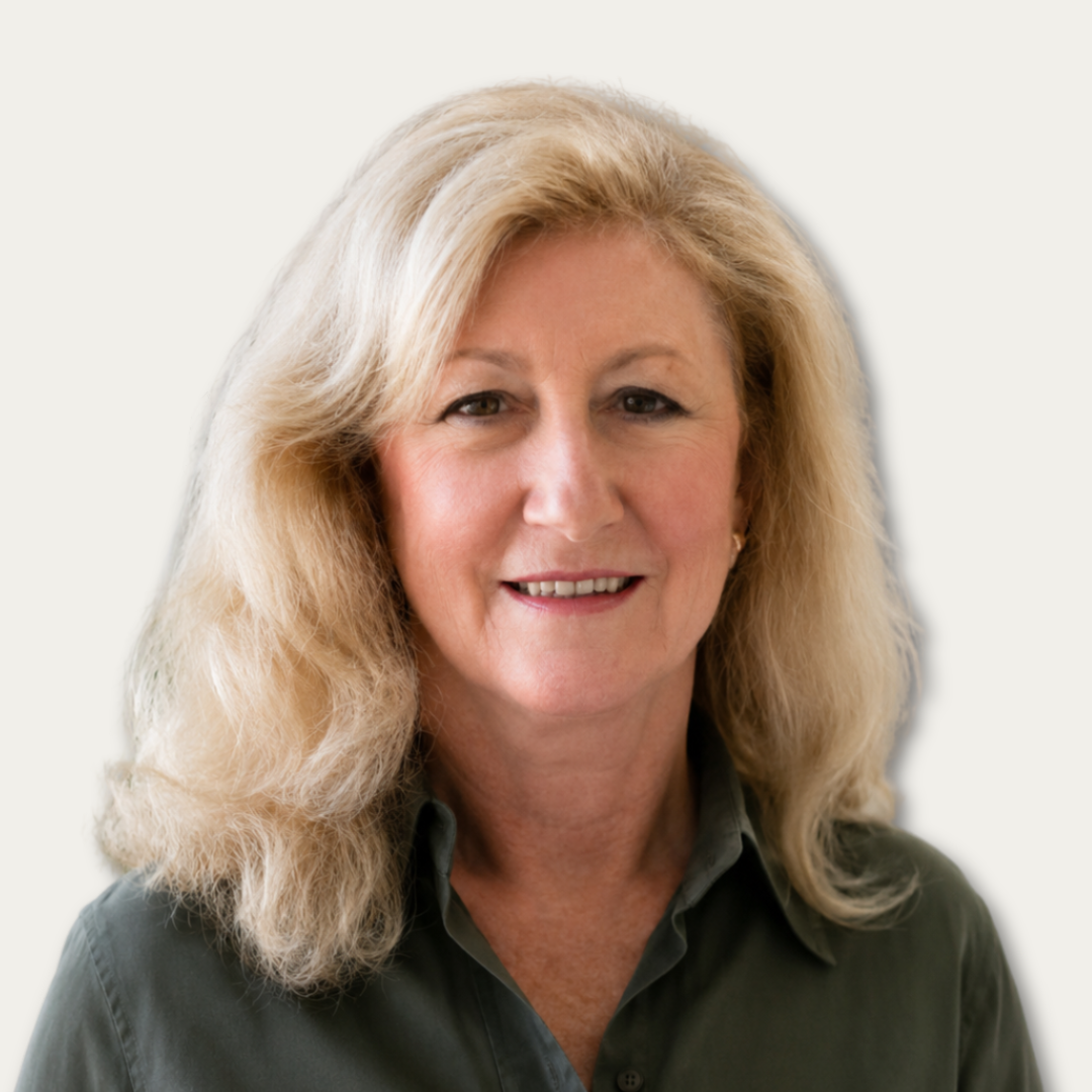Smiling woman with long blonde hair wearing a dark green collared shirt, posed in front of a light background.
