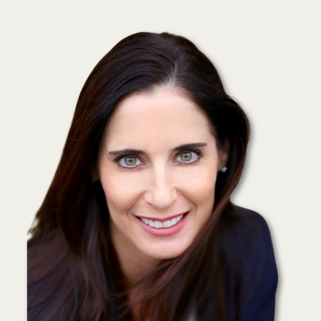 Woman with long dark hair and green eyes, wearing a dark top, smiling at the camera against a light background.